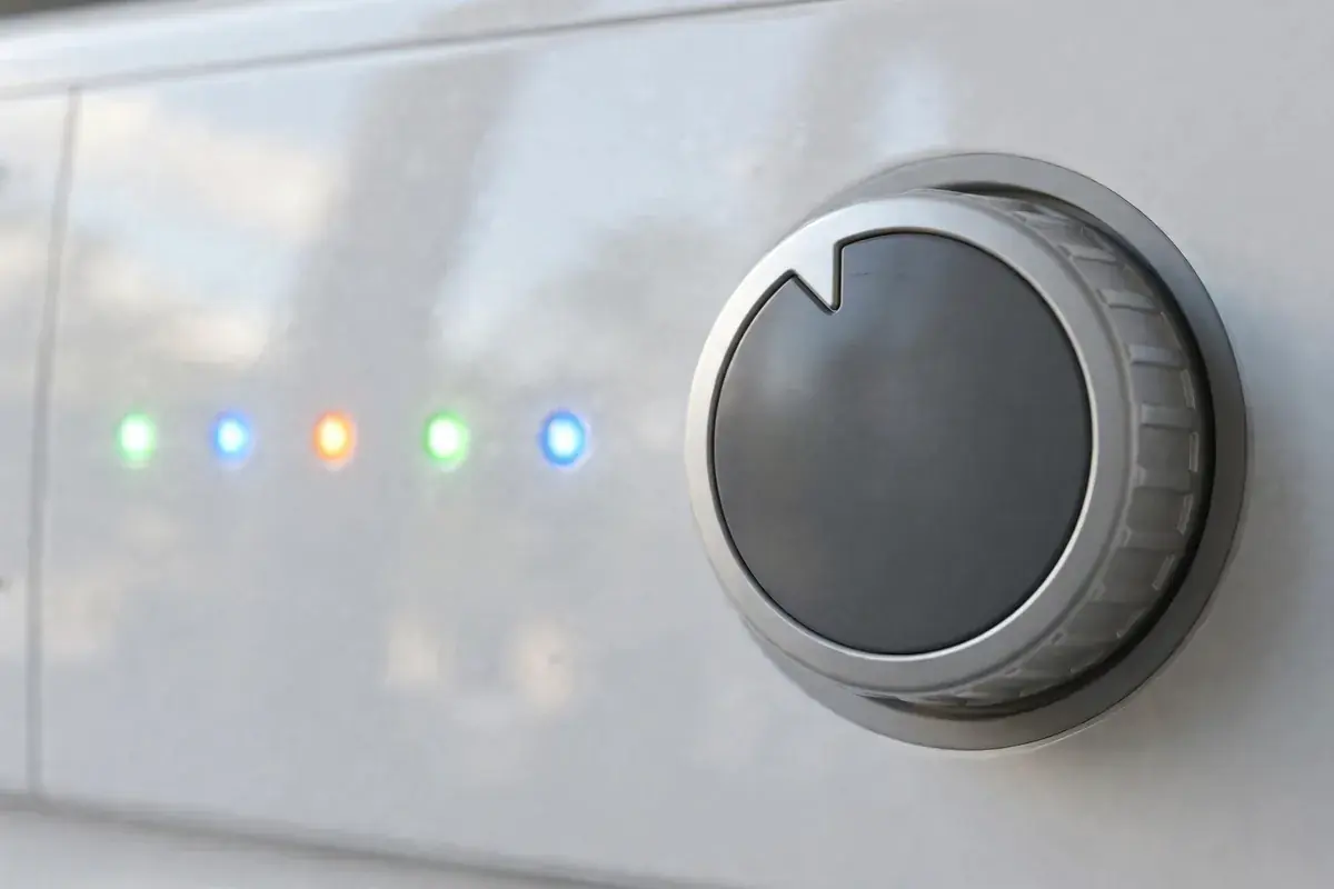 Washer control panel with a selector dial and a row of lit indicator lights